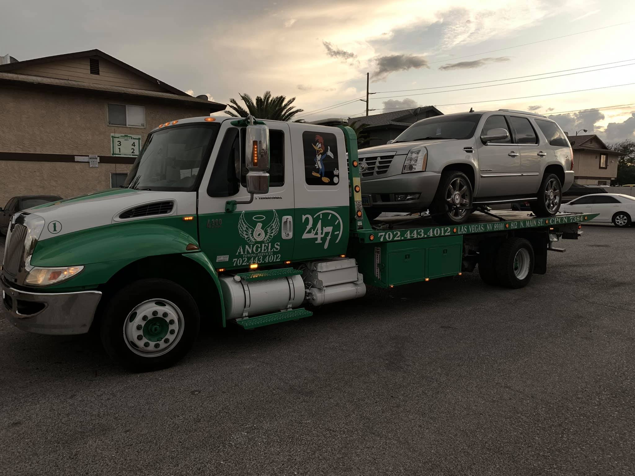 6 Angels tow truck with SUV loaded at sunset